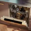 Inside of an open dishwasher with dishes stacked. Produktbild-Vorschau