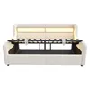 A white sofa bed with its mattress frame extended, showing the storage space underneath. Produktbild-Vorschau