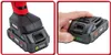 Two close-up images of a red and black power tool battery pack. The left image shows the battery attached to a tool. The right image shows a hand pressing a button on the battery to check its charge level. Náhled obrázku produktu