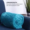 A rolled-up teal blanket is placed on a dark blue armchair, with text overlay describing its features. Náhľad obrázku produktu