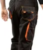 Close-up view of the back of black work pants with orange accents. Produktbild-Vorschau