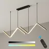 A modern LED pendant light with a zigzag design, suspended from a black ceiling mount. The light is illuminated with a warm white glow, and a remote control is shown in the lower right corner, along with color gradient bars indicating adjustable color temp Produktbild-Vorschau