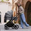 A woman pushing a stroller down a cobblestone street. Náhled obrázku produktu