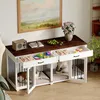 A dog crate furniture piece with two compartments, each with a drawer above and a door below, set up in a room with a painting on the wall and plants. Produktbild-Vorschau