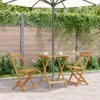 A small wooden table and two chairs are set up on a patio under a large umbrella, surrounded by greenery. Produktbild-Vorschau