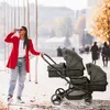 A woman is pushing a twin stroller on a sunny day. Produktbild-Vorschau