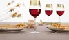 A table setting with three wine glasses filled with red wine, plates, and decorative dried flowers. Podgląd zdjęcia produktu