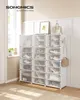 A white shoe rack with multiple compartments filled with shoes and bags, placed in a room with natural light coming from a window. Produktbild-Vorschau