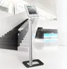 A tablet stand in a modern lobby with a staircase. Produktbild-Vorschau