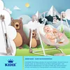 A baby in a swing with cartoon bears and mountains in the background. Produktbild-Vorschau