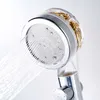A close-up shot of a chrome shower head with water spraying from it. Produktbild-Vorschau