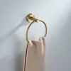 A gold-colored towel ring mounted on a light gray wall, with a beige towel hanging from it. Podgląd zdjęcia produktu