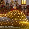 A young girl is interacting with a bush decorated with net lights, with Christmas trees and gifts in the background. Produktbild-Vorschau