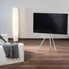 A modern living room with a white sofa, a floor lamp, and a TV on a tripod stand. Voir les images du produit