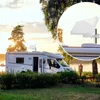 A motorhome is parked by a lake at sunset, with a satellite dish mounted on its roof. Produktbild-Vorschau