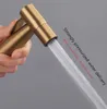 A hand holding a gold bidet sprayer with water spraying out. Produktbild-Vorschau