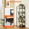 A tall, narrow bookshelf with a rustic wood finish and black metal frame, decorated with several potted plants and a watering can. Insets highlight anti-tipping device and adjustable feet. Podgląd zdjęcia produktu