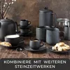 A collection of black ceramic coffee cups, saucers, a teapot, and a jar on a wooden surface. Produktbild-Vorschau