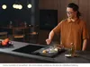 A man is cooking on a modern induction hob with an integrated extractor fan in a stylish kitchen. Anteprima dell’immagine prodotto