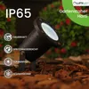 A black garden spotlight with water droplets on it, placed on mulch, with a blurred background of green foliage and red flowers. Text overlays describe its features. Náhľad obrázku produktu