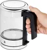 A hand is holding the handle of a glass electric kettle. Náhled obrázku produktu