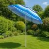 A striped beach umbrella is set up in a lush green garden on a sunny day. Náhled obrázku produktu
