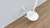 A close-up view of a white floor lamp's base and power cord plugged into a wall outlet. Anteprima dell’immagine prodotto