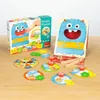 A children's board game called "Hungry Monster" is displayed on a wooden table. Podgląd zdjęcia produktu