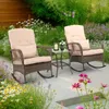 Two wicker rocking chairs and a small table are set up on a patio surrounded by lush greenery and flowers. Podgląd zdjęcia produktu