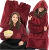 A collage of a girl wearing a red hoodie blanket and holding a bowl of popcorn, and a folded red hoodie blanket. Produktbild-Vorschau