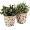 Two decorative ceramic pots with a strawberry pattern, each containing a faux plant. Produktbild-Vorschau
