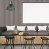 A modern living room scene with a sofa, coffee table, and stools, featuring a wall with vertical paneling and a large blank frame. Náhľad obrázku produktu