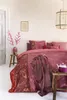 A bedroom scene with a bed dressed in pink floral bedding, a throw blanket, and decorative items. Produktbild-Vorschau