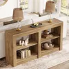 A wooden console table with shelves, decorated with lamps, books, candles, and decorative spheres, placed behind a sofa in a living room setting. Produktbild-Vorschau