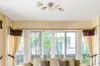A living room with a ceiling light fixture above sliding glass doors and curtains. Podgląd zdjęcia produktu
