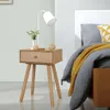 A bedside table with a lamp and decorative items next to a bed. Náhled obrázku produktu