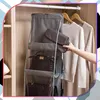 A hand is shown placing a clutch into a hanging closet organizer filled with handbags and sweaters. Produktbild-Vorschau