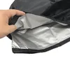 A hand is holding open a black grill cover to show its silver lining. Náhľad obrázku produktu