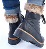 A close-up shot of a pair of black leather boots with fur trim, worn with blue jeans. Anteprima dell’immagine prodotto