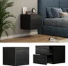 A modern bedroom setting with a black high-gloss nightstand mounted on a ribbed wall next to a blue upholstered bed. Podgląd zdjęcia produktu