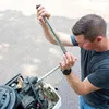 A man is working on a boat engine outdoors. Anteprima dell’immagine prodotto