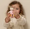A young girl holds a small doll in her hands. Náhľad obrázku produktu