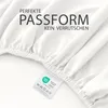 A close-up view of a white fitted sheet with text overlays and a product tag. Produktbild-Vorschau