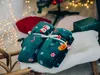 Christmas-themed blankets tied together, placed on a fluffy white surface, with a Christmas tree and lights in the background. Náhľad obrázku produktu