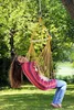 A woman is relaxing in a hammock chair in a garden. Produktbild-Vorschau