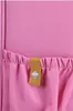 A close-up view of a pink fabric with a yellow tag attached to a gathered section. Anteprima dell’immagine prodotto