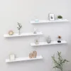 Four white shelves mounted on a light gray wall, decorated with various items. Voir les images du produit