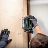 A person is using a cordless jigsaw to cut a wooden surface. Podgląd zdjęcia produktu