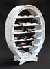 A white wooden wine rack shaped like a barrel, filled with dark red wine bottles, against a black background. Produktbild-Vorschau