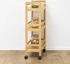 A wooden trolley with three shelves, each holding a glass jar filled with food items, is placed against a white wall and on a wooden floor. Podgląd zdjęcia produktu